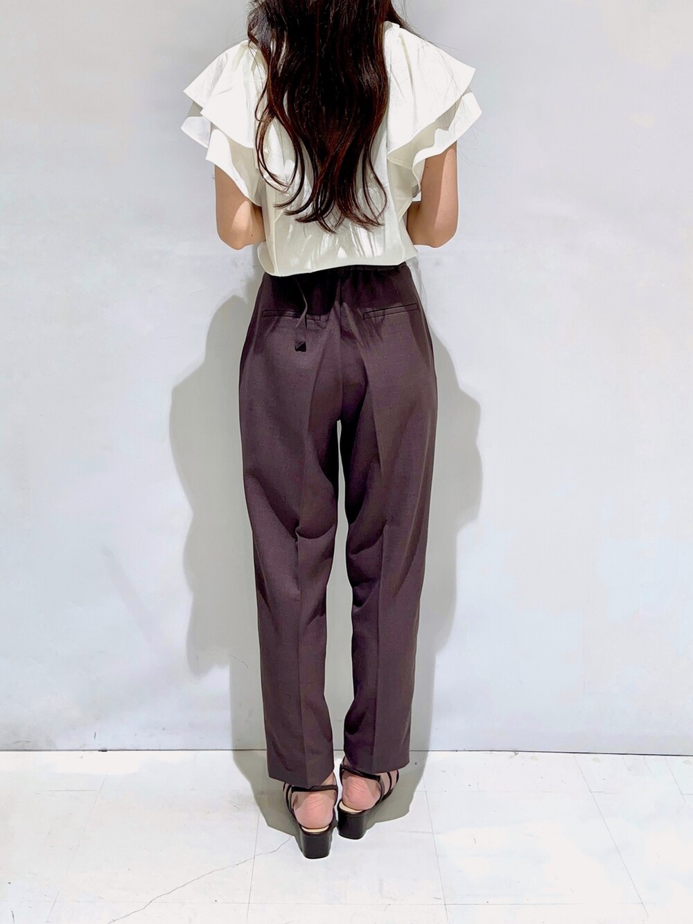 ホワイト系のTシャツ/カットソー、ブラウン系のその他パンツ、ブラック系のサンダルを着用したレディースの夏コーディネートの3枚目の写真