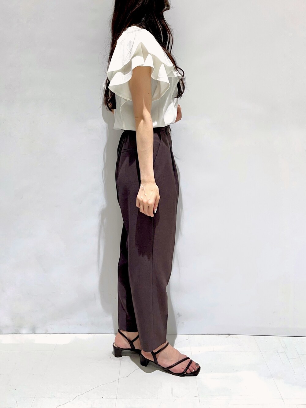 ホワイト系のTシャツ/カットソー、ブラウン系のその他パンツ、ブラック系のサンダルを着用したレディースの夏コーディネートの2枚目の写真