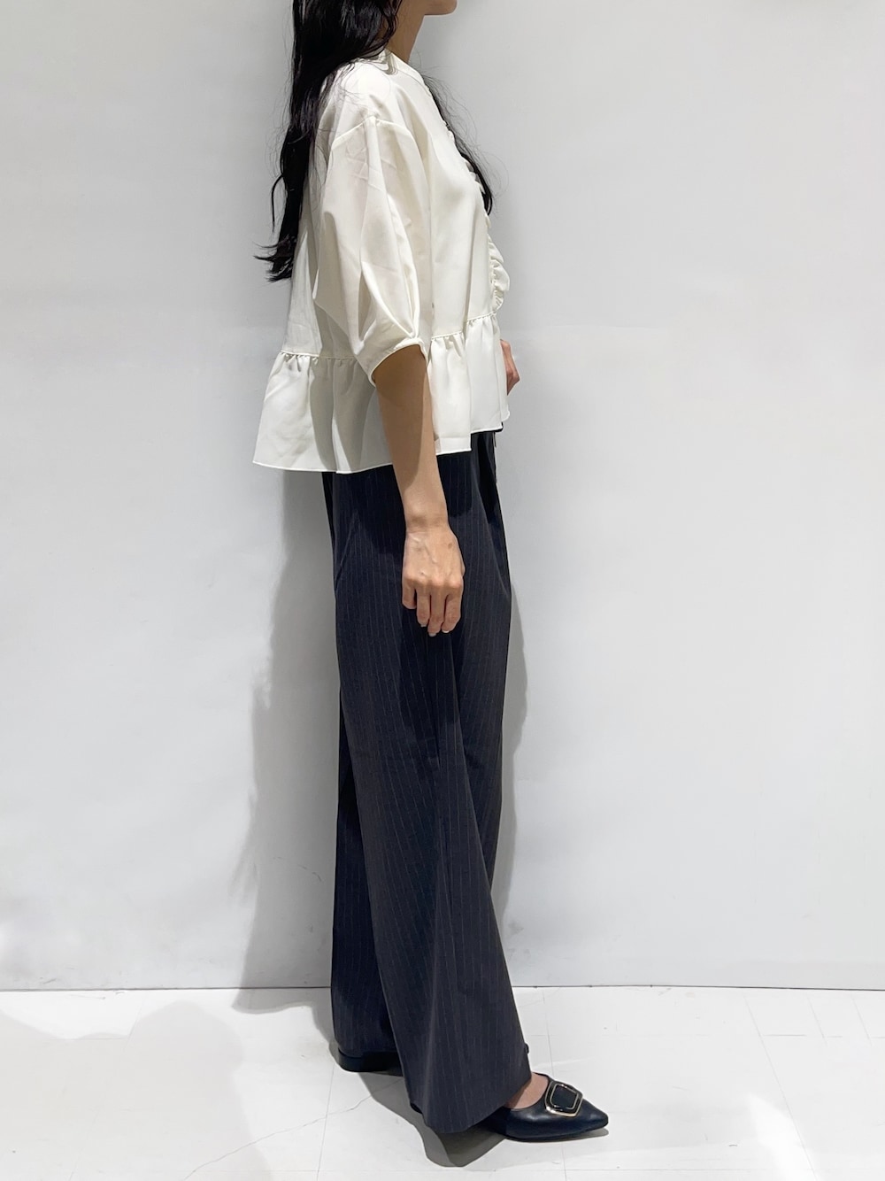ホワイト系のシャツ/ブラウス、グレー系のその他パンツ、ブラック系のパンプスを着用したレディースの秋コーディネートの2枚目の写真