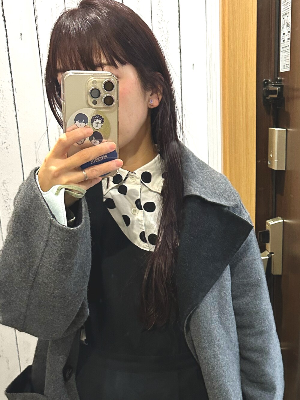 グレー系のダウンジャケット/コート、ブラック系のジャンパースカート、グレー系のローファーを着用したレディースの秋コーディネートの3枚目の写真