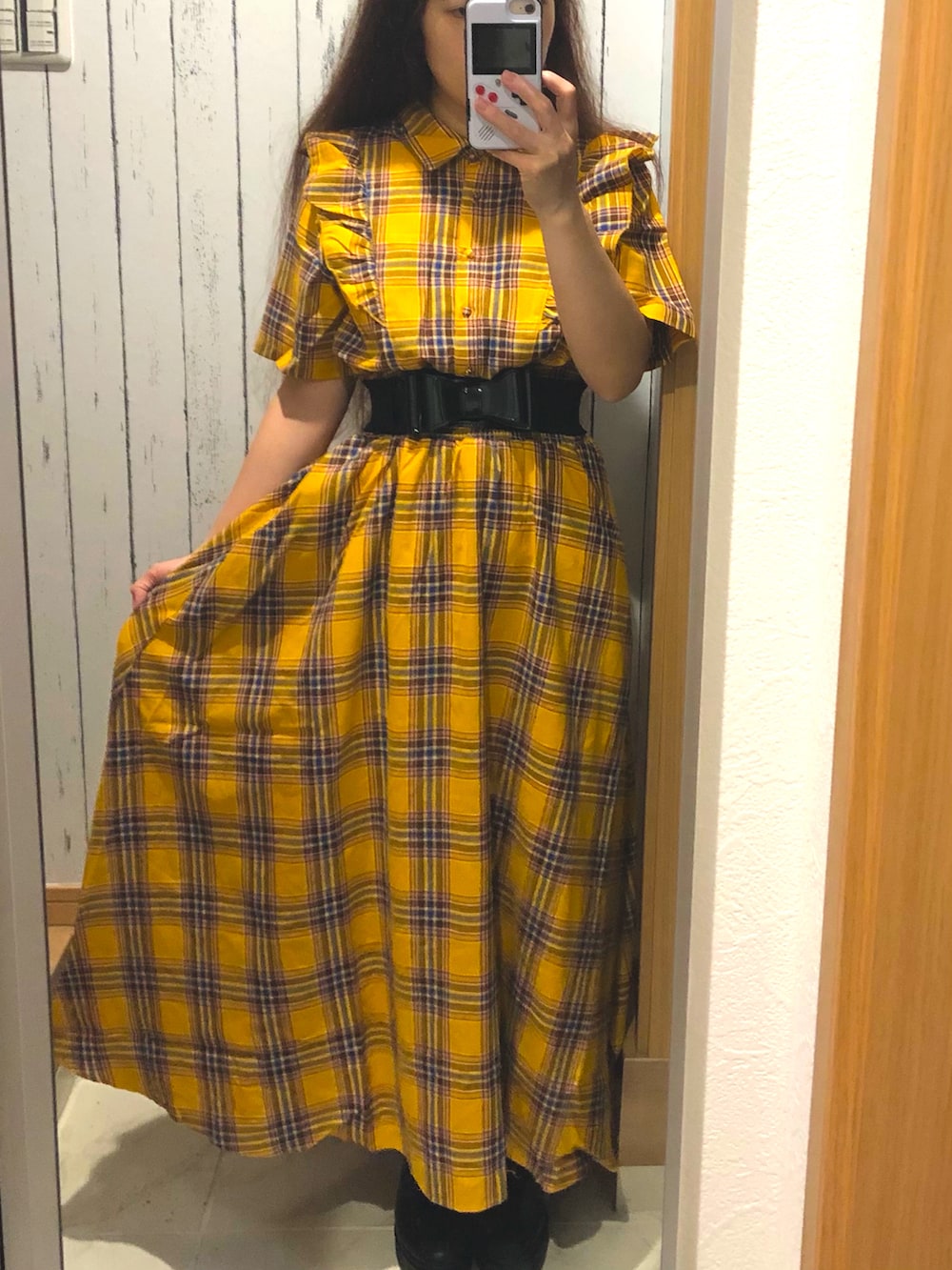 イエロー系のワンピース、ブラック系のローファーを着用したレディースの春コーディネートの2枚目の写真