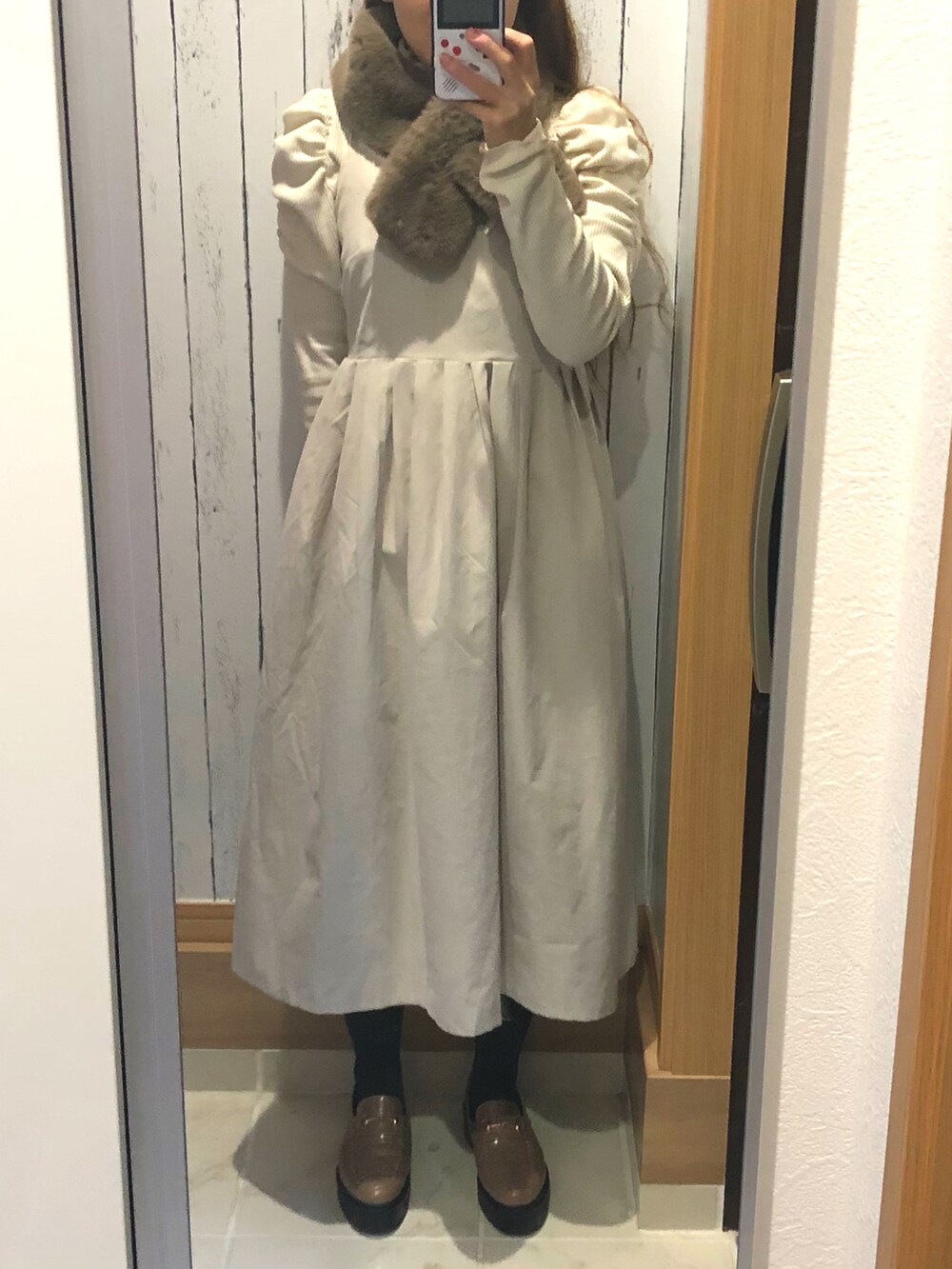 ベージュ系のワンピース、ホワイト系のTシャツ/カットソー、グレー系のローファーを着用したレディースの冬コーディネートの2枚目の写真