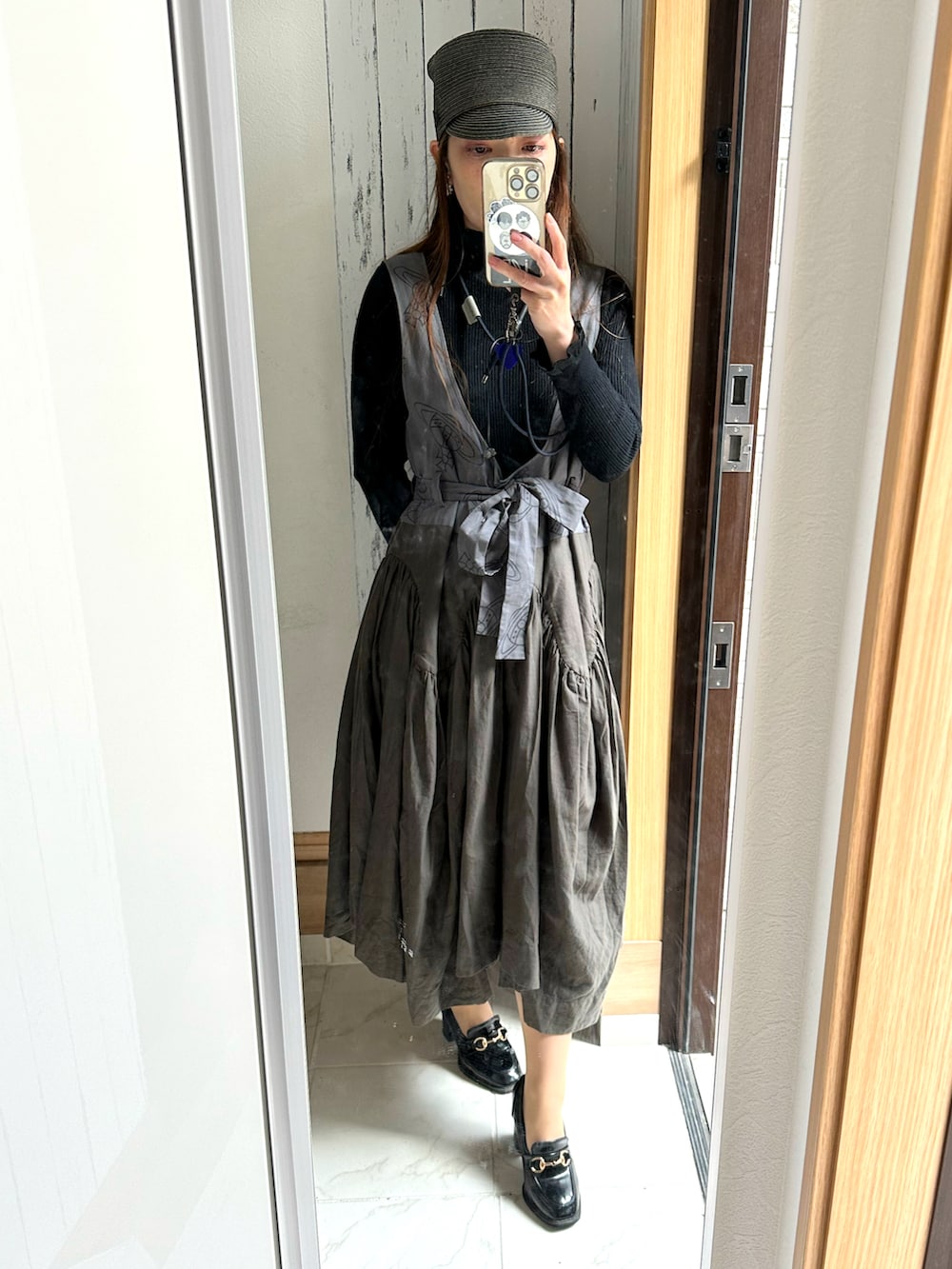 グレー系のダウンジャケット/コート、グレー系のワンピース/ドレス、ブラック系のニット/セーターを着用したレディースの春コーディネートの3枚目の写真