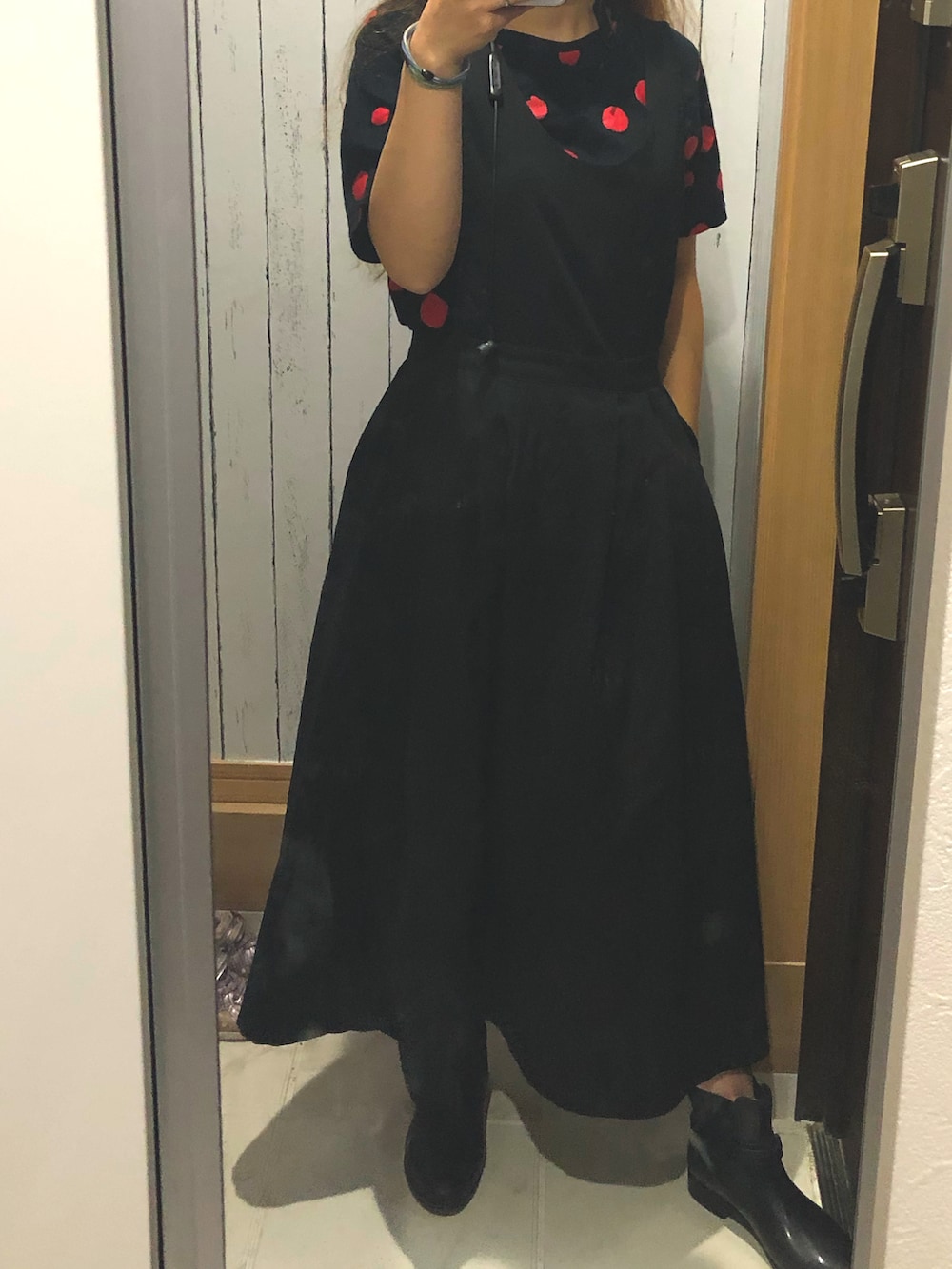 ブラック系のジャンパースカート、ブラック系のTシャツ/カットソー、ブラック系のレインシューズを着用したレディースの秋コーディネートの2枚目の写真