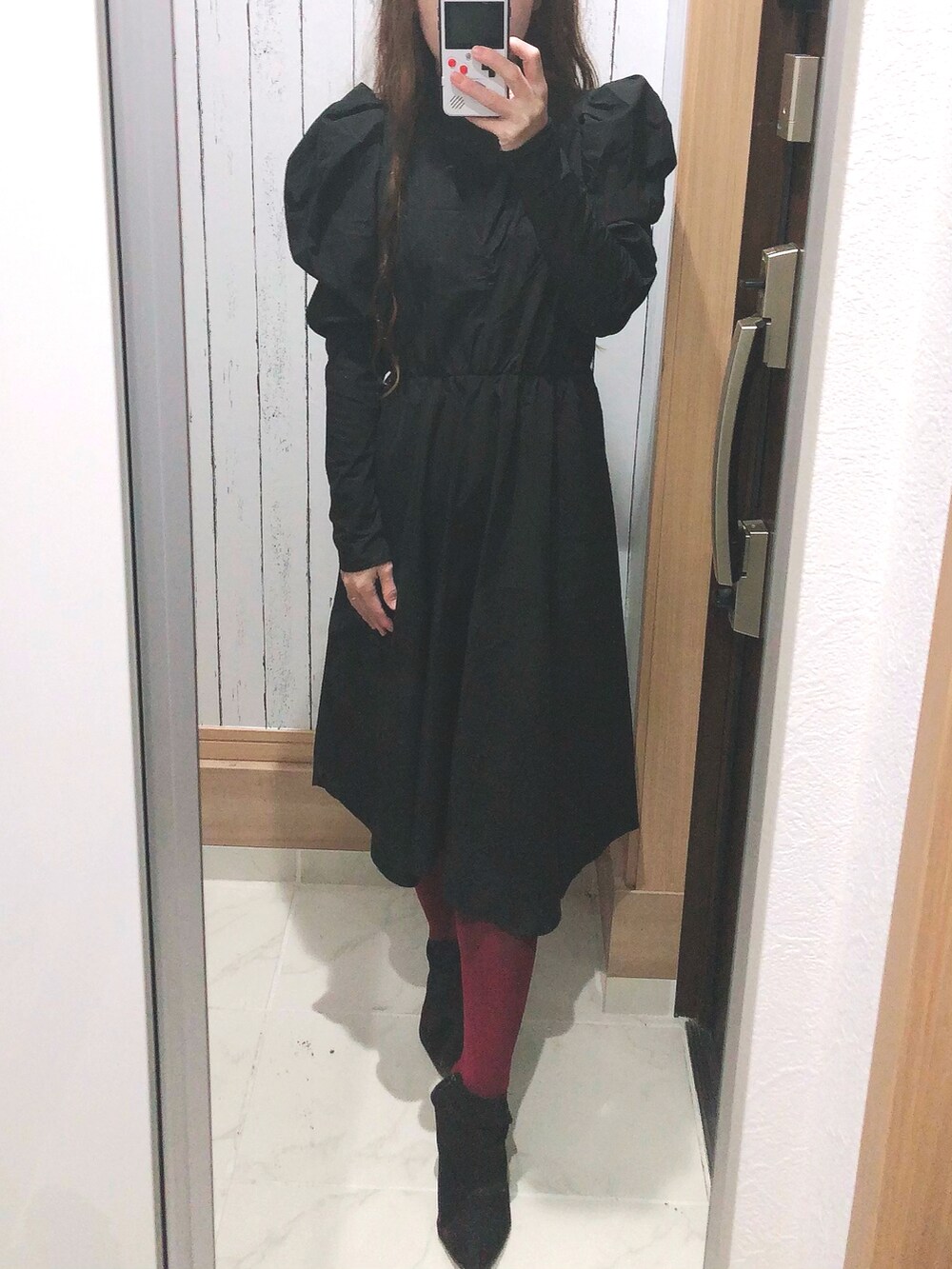 ブラック系のワンピース、ブラック系のブーツを着用したレディースの冬コーディネートの2枚目の写真
