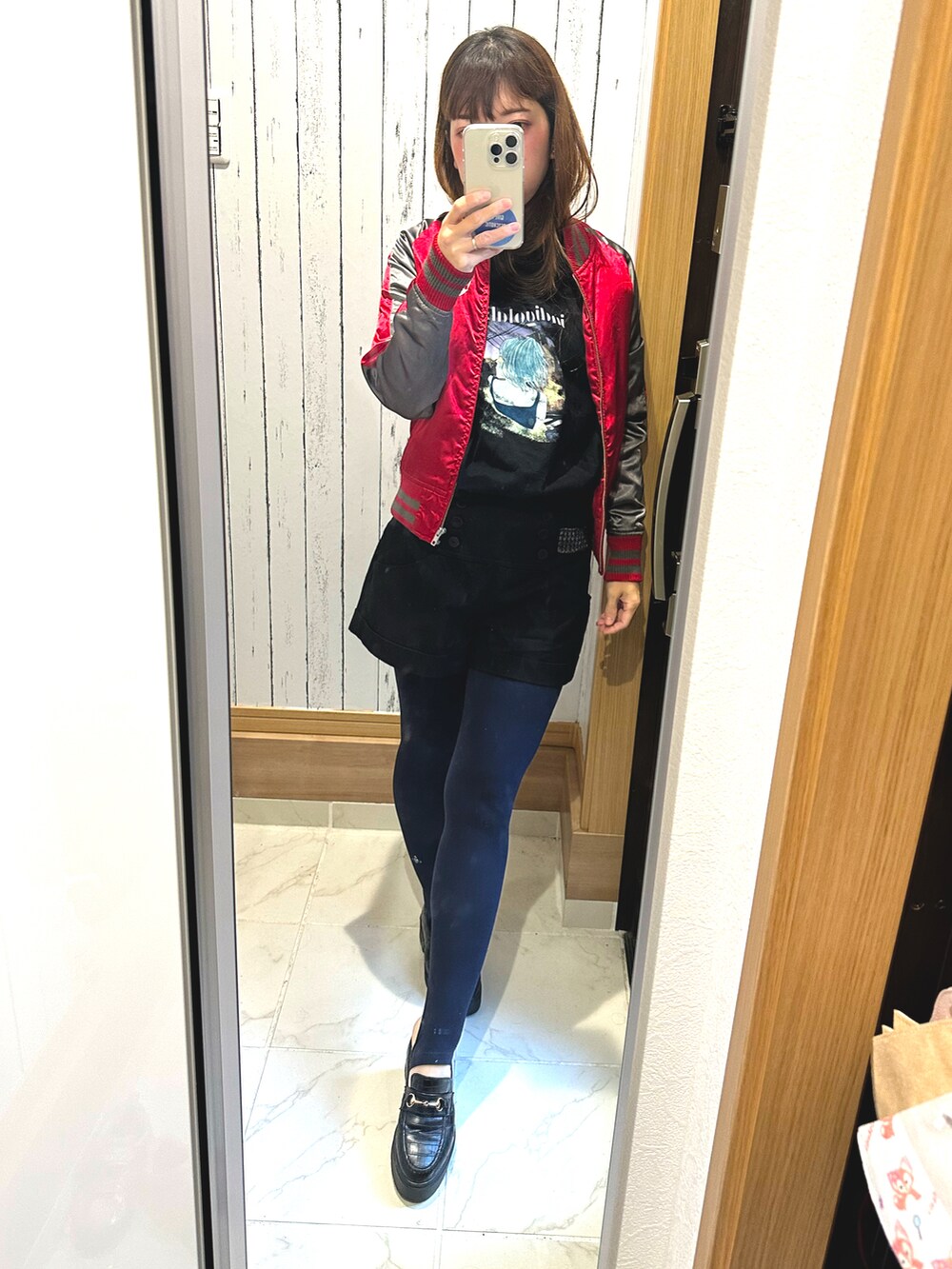 レッド系のスカジャン、ブラック系のパンツ、ブラック系のTシャツ/カットソーを着用したレディースの冬コーディネートの2枚目の写真