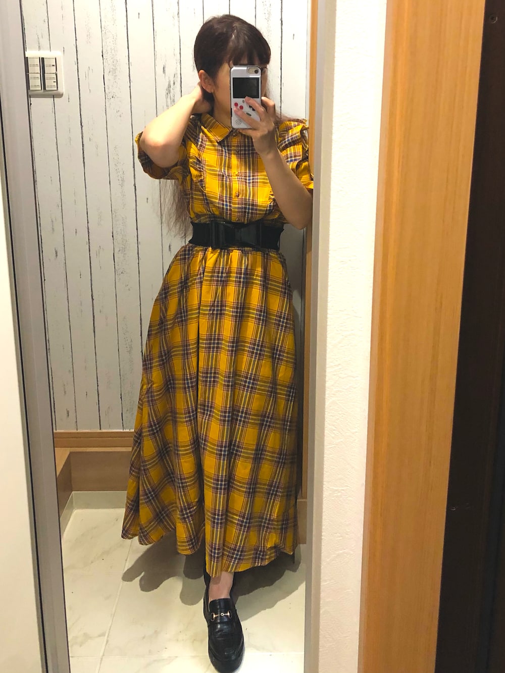 イエロー系のワンピース、ブラック系のローファーを着用したレディースの春コーディネートの3枚目の写真