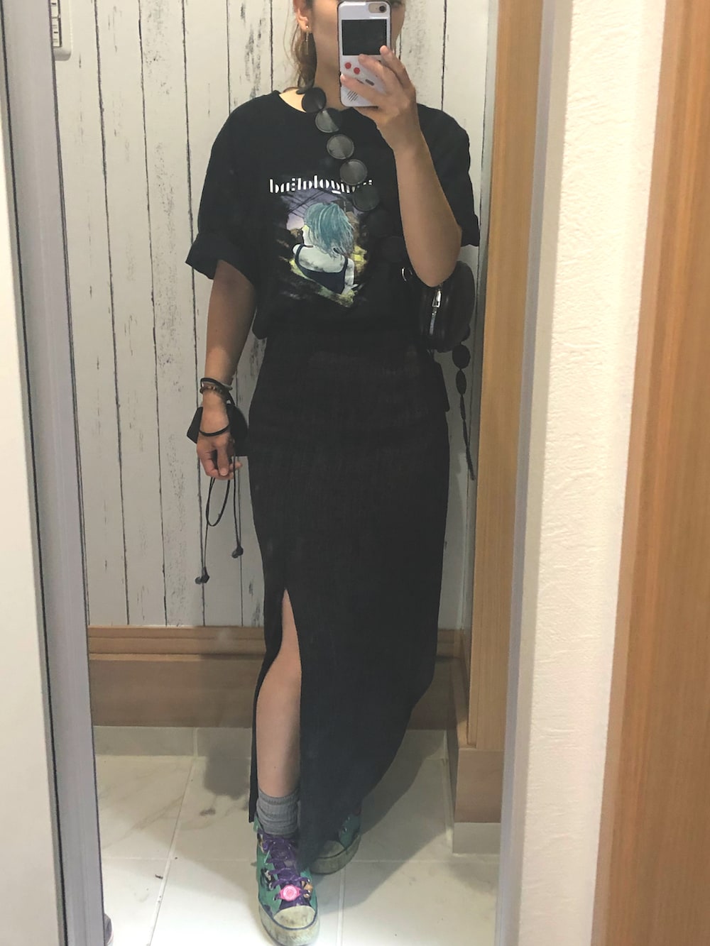 ブラック系のTシャツ/カットソー、ブラック系のスカート、グリーン系のスニーカーを着用したレディースの夏コーディネートの2枚目の写真