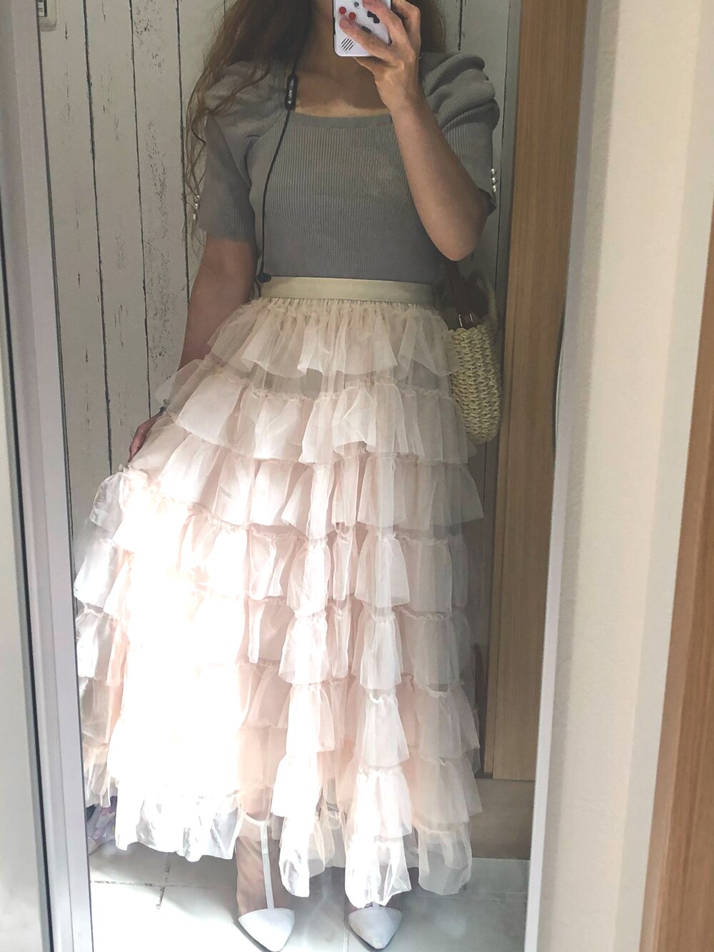 ホワイト系のスカート、ブルー系のニット/セーター、ベージュ系のかごバッグを着用したレディースの夏コーディネートの2枚目の写真