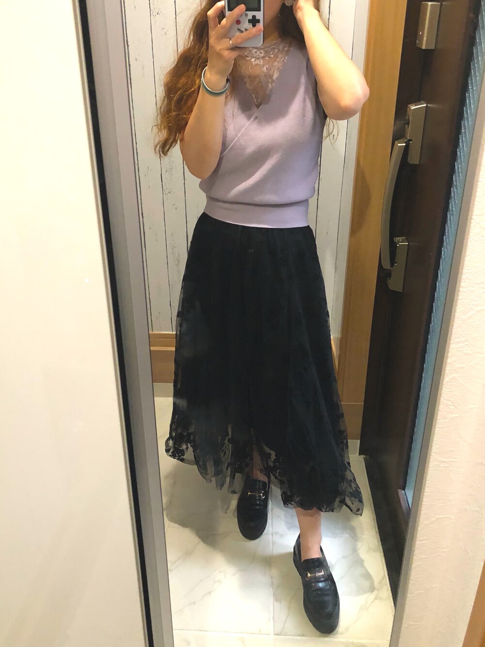 ブラック系のスカート、パープル系のニット/セーター、ブラック系のローファーを着用したレディースの秋コーディネートの2枚目の写真