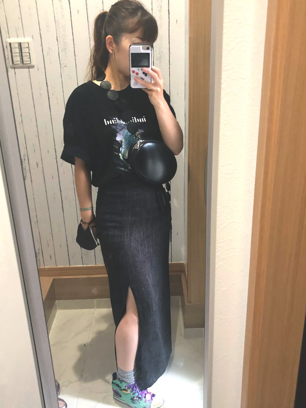 ブラック系のTシャツ/カットソー、ブラック系のスカート、グリーン系のスニーカーを着用したレディースの夏コーディネートの3枚目の写真