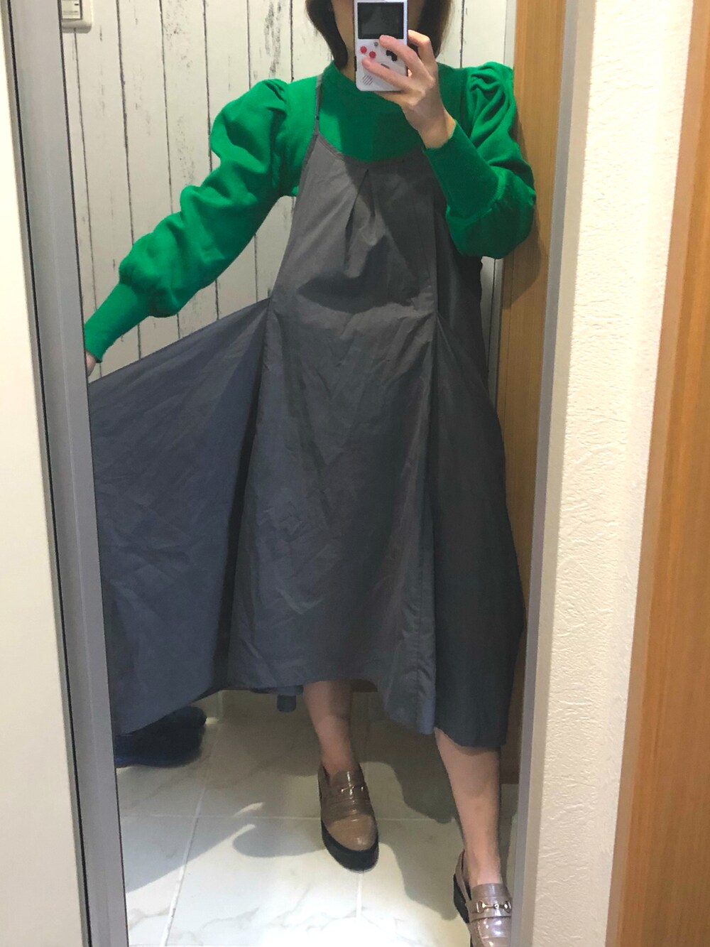 グレー系のワンピース、グリーン系のニット/セーター、グレー系のローファーを着用したレディースの春コーディネートの2枚目の写真