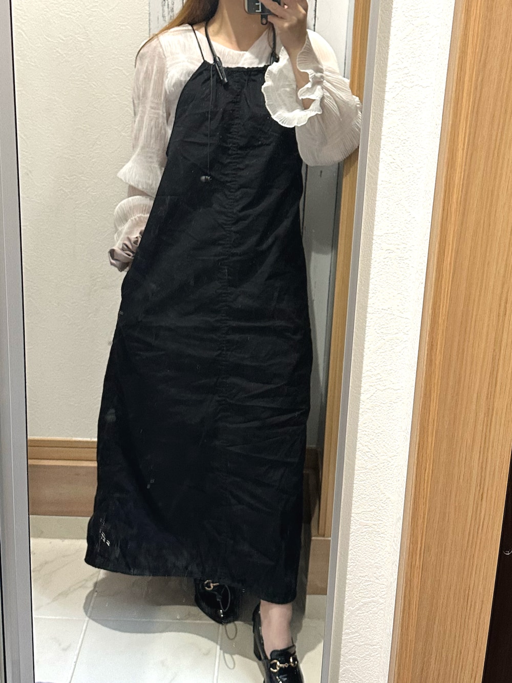 ブラック系のワンピース、ホワイト系のシャツ/ブラウスを着用したレディースの春コーディネートの2枚目の写真