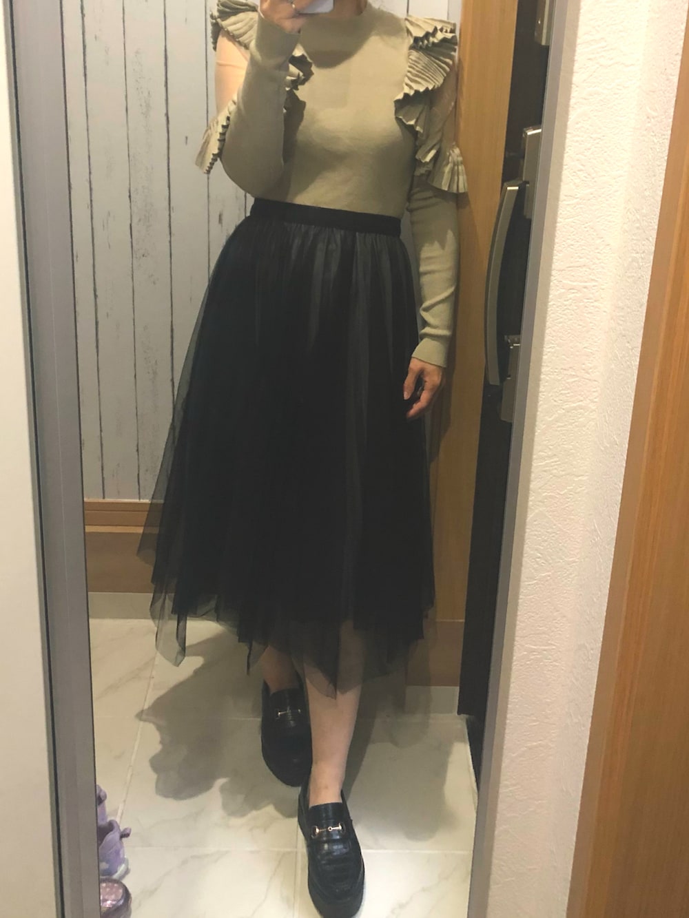 ブラック系のスカート、グリーン系のニット/セーターを着用したレディースの春コーディネートの2枚目の写真