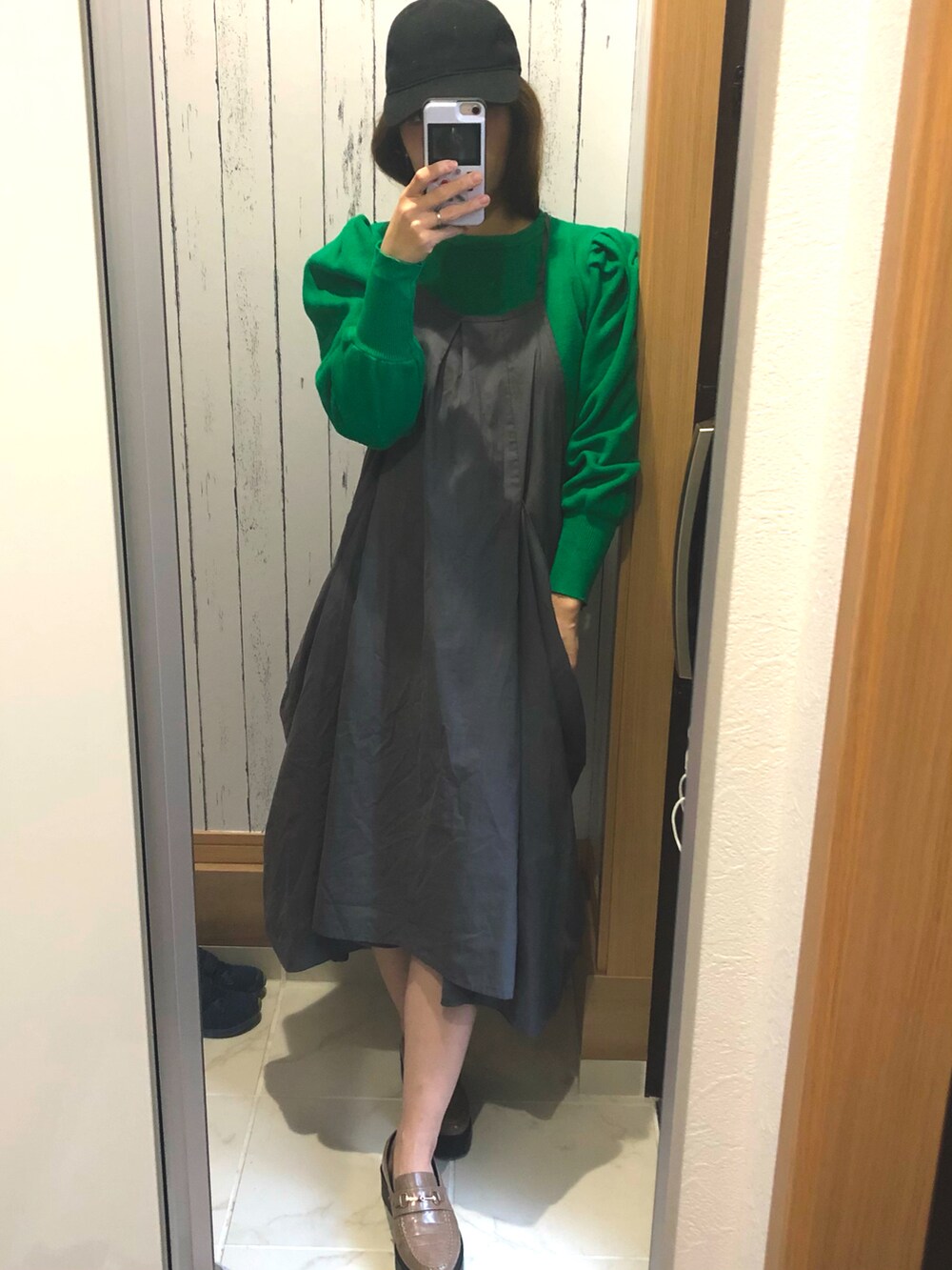 グレー系のワンピース、グリーン系のニット/セーター、グレー系のローファーを着用したレディースの春コーディネートの3枚目の写真