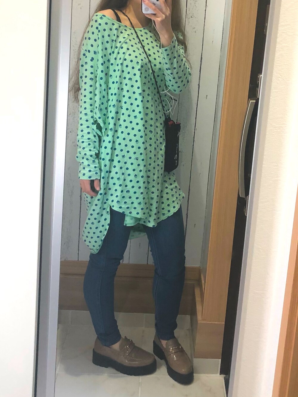 ブルー系のデニムパンツ、グレー系のローファー、グリーン系のワンピースを着用したレディースの春コーディネートの2枚目の写真