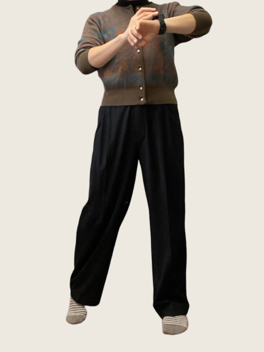 ブラウン系のニット/セーター、ブラック系のパンツを着用したレディースの冬コーディネートの2枚目の写真