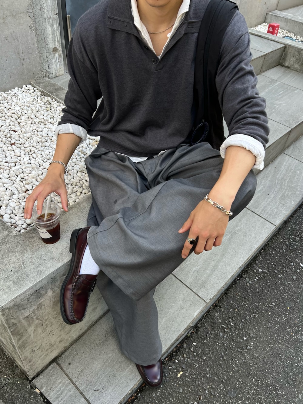 グレー系のニット/セーター、グレー系のスラックス、レッド系のローファーを着用したメンズの秋コーディネートの2枚目の写真