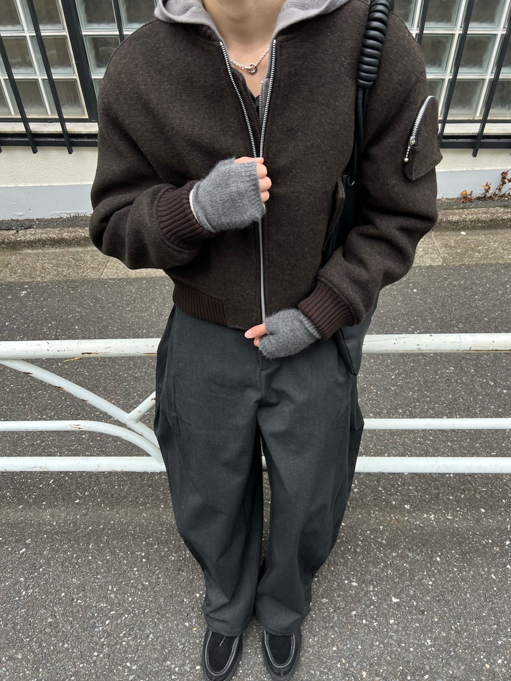 ブラウン系のMA-1、ブラック系のスラックス、ブラック系のトートバッグを着用したメンズの冬コーディネートの3枚目の写真