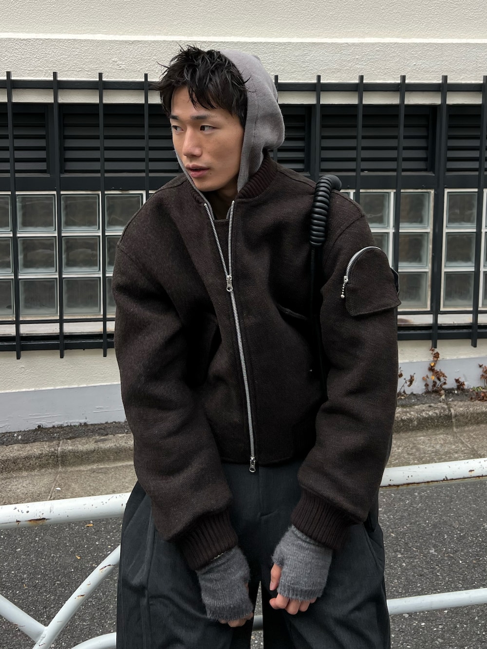 ブラウン系のMA-1、ブラック系のスラックス、ブラック系のトートバッグを着用したメンズの冬コーディネートの2枚目の写真
