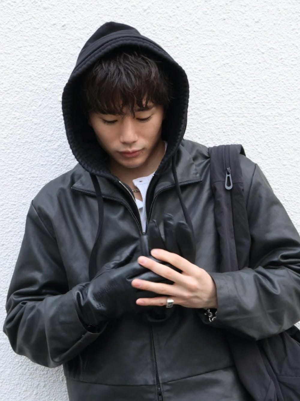 ブラック系のスニーカー、ブラック系のデニムパンツ、ブラック系の手袋を着用したメンズの冬コーディネートの2枚目の写真