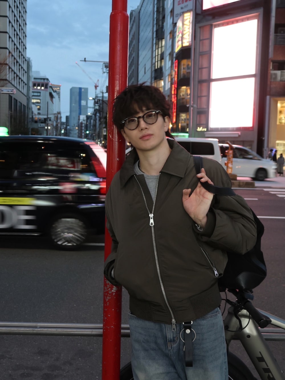 ブラック系のローファー、ブルー系のデニムパンツ、ブラック系のバッグを着用したメンズの春コーディネートの2枚目の写真