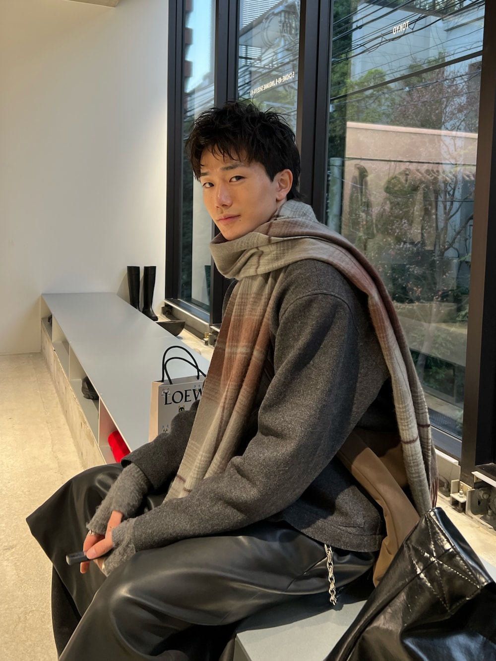 レッド系のローファー、ブラック系のその他パンツ、ブラウン系のショルダーバッグを着用したメンズの冬コーディネートの2枚目の写真