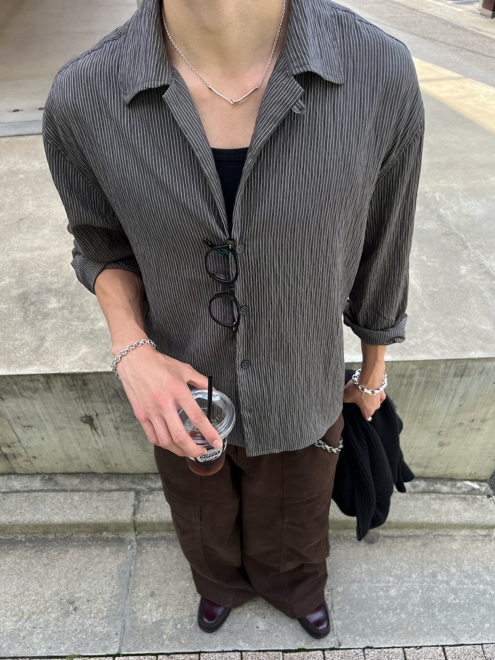 ブラック系のニット/セーター、レッド系のローファー、ブラウン系のデニムパンツを着用したメンズの秋コーディネートの2枚目の写真