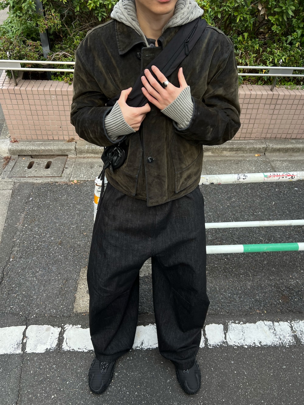 グリーン系のジャケット/アウター、ブラック系のデニムパンツ、ブラック系のスニーカーを着用したメンズの冬コーディネートの3枚目の写真