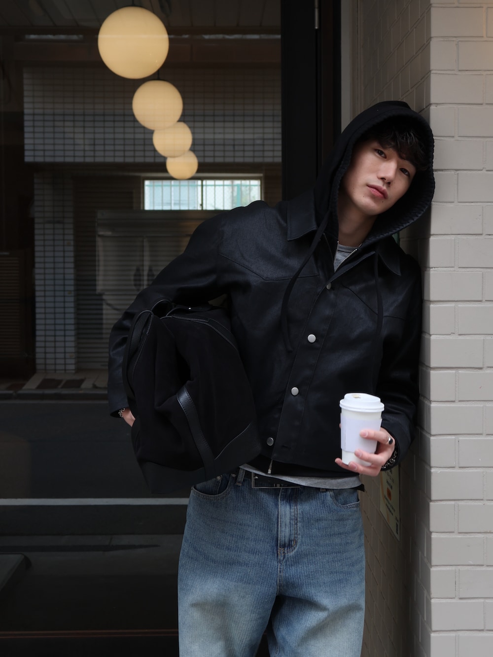 ブラック系のローファー、ブルー系のデニムパンツを着用したメンズの春コーディネートの2枚目の写真