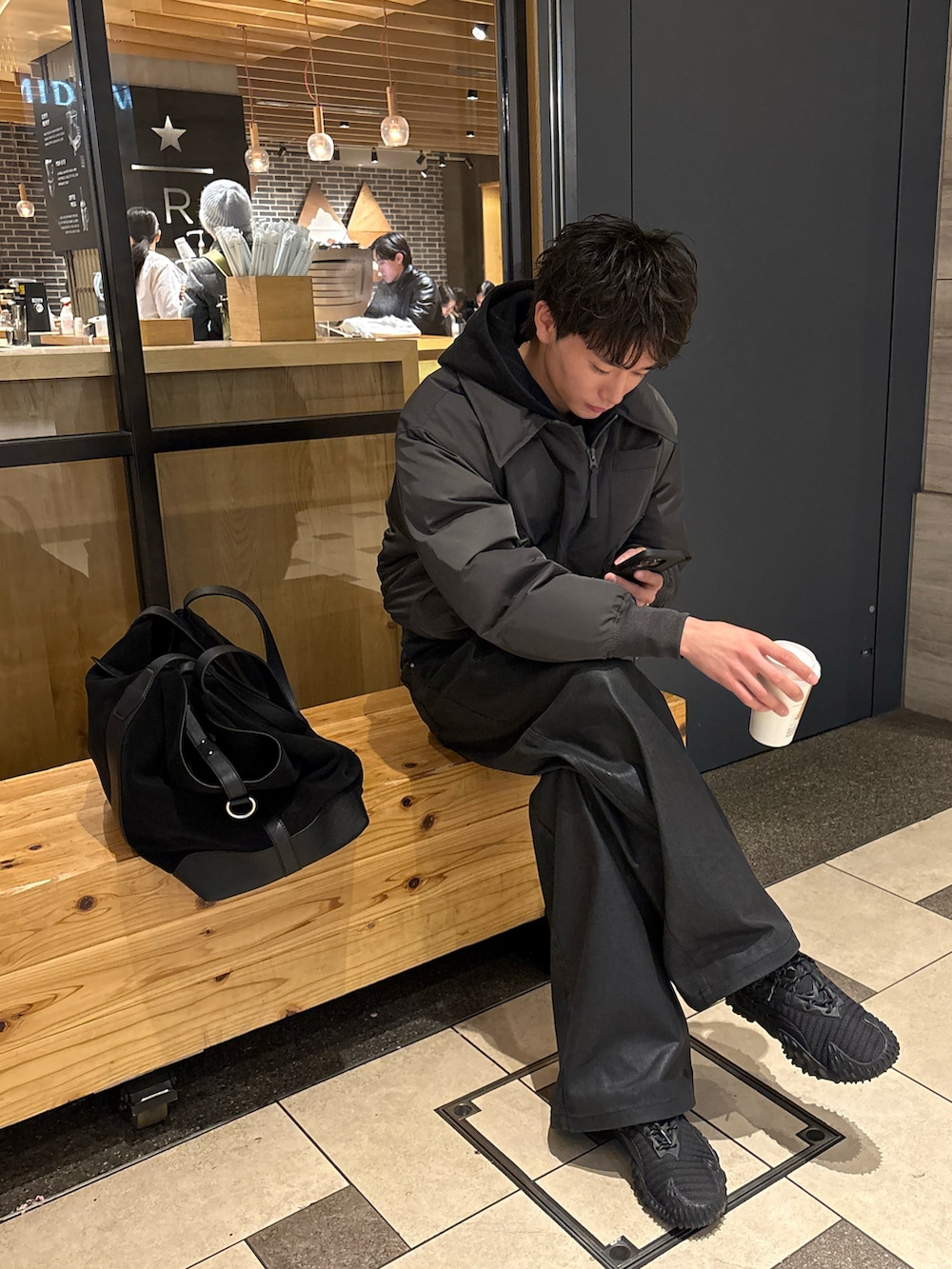ブラック系のスニーカー、ブラック系のデニムパンツ、グレー系のブルゾンを着用したメンズの冬コーディネートの2枚目の写真