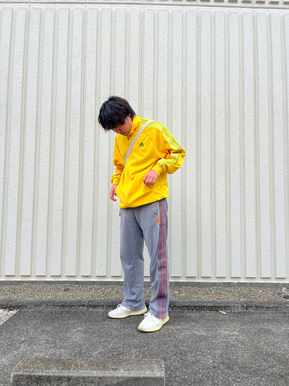 イエロー系のジャケット/アウター、ベージュ系のショルダーバッグ、グレー系のその他パンツを着用したメンズの春コーディネートの2枚目の写真