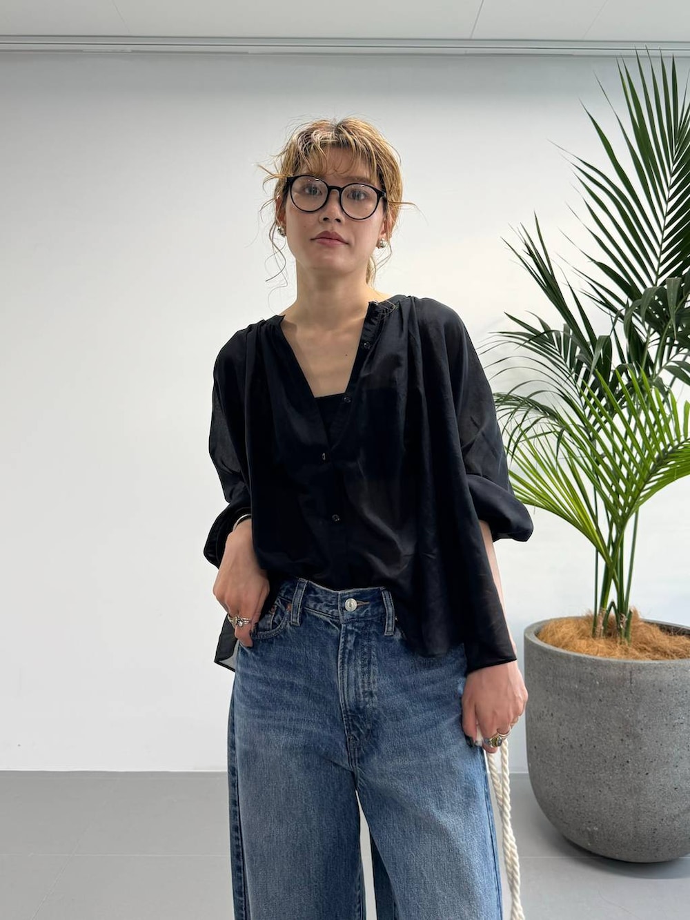 ブラック系のシャツ/ブラウス、ブルー系のデニムパンツ、ブルー系のハンドバッグを着用したレディースの夏コーディネートの9枚目の写真