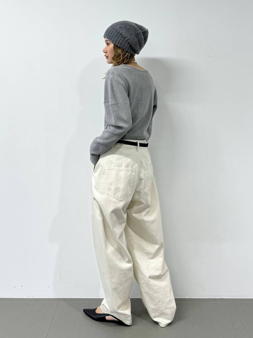 グレー系のTシャツ/カットソー、ホワイト系のその他パンツ、グレー系のニットキャップ/ビーニーを着用したレディースの冬コーディネートの7枚目の写真