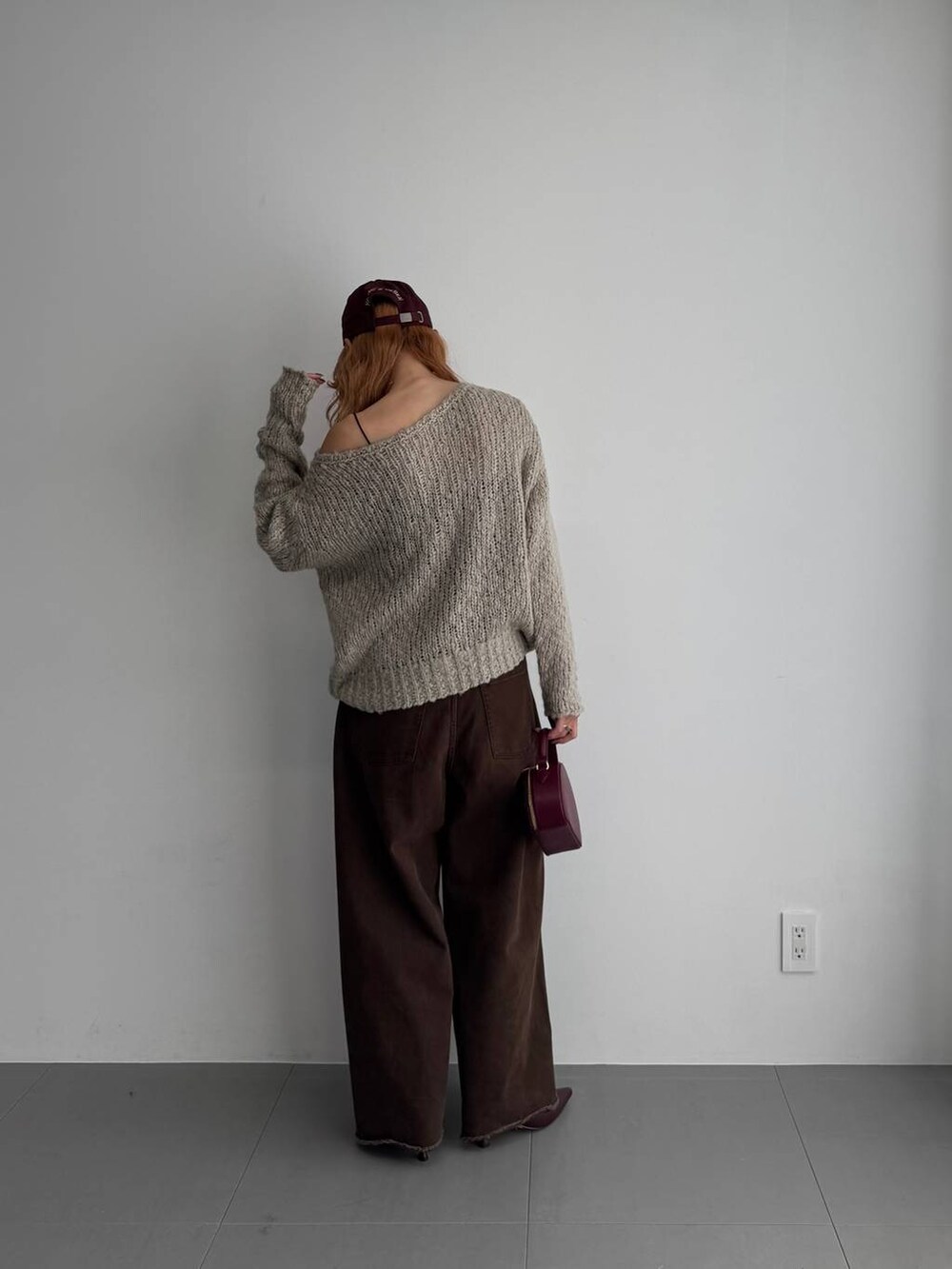 グリーン系のニット/セーター、レッド系のハンドバッグ、レッド系のブーツを着用したレディースの秋コーディネートの6枚目の写真