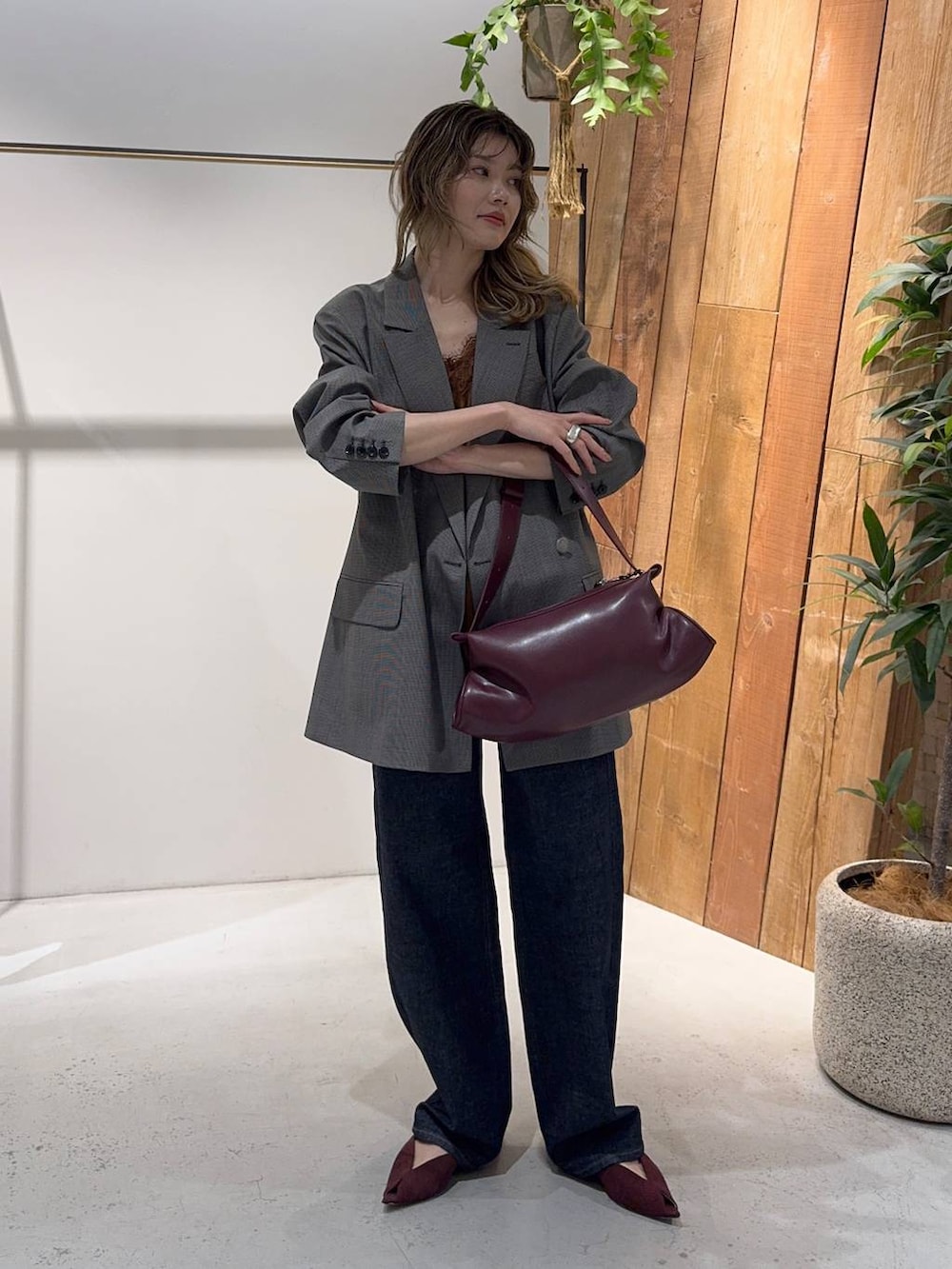 レッド系のパンプス、ブラウン系のテーラードジャケット、ブルー系のデニムパンツを着用したレディースの秋コーディネートの6枚目の写真