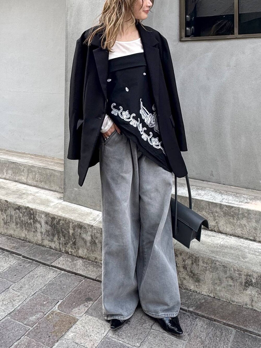 グレー系のデニムパンツ、ブラック系のテーラードジャケット、ホワイト系のTシャツ/カットソーを着用したレディースの春コーディネートの4枚目の写真