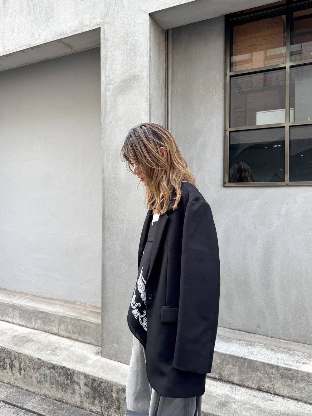 グレー系のデニムパンツ、ブラック系のテーラードジャケット、ホワイト系のTシャツ/カットソーを着用したレディースの春コーディネートの8枚目の写真