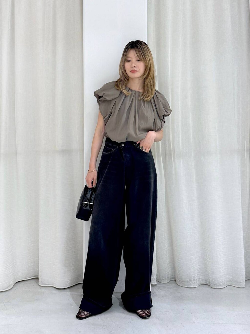 ブラック系のデニムパンツ、ベージュ系のシャツ/ブラウスを着用したレディースの夏コーディネートの2枚目の写真