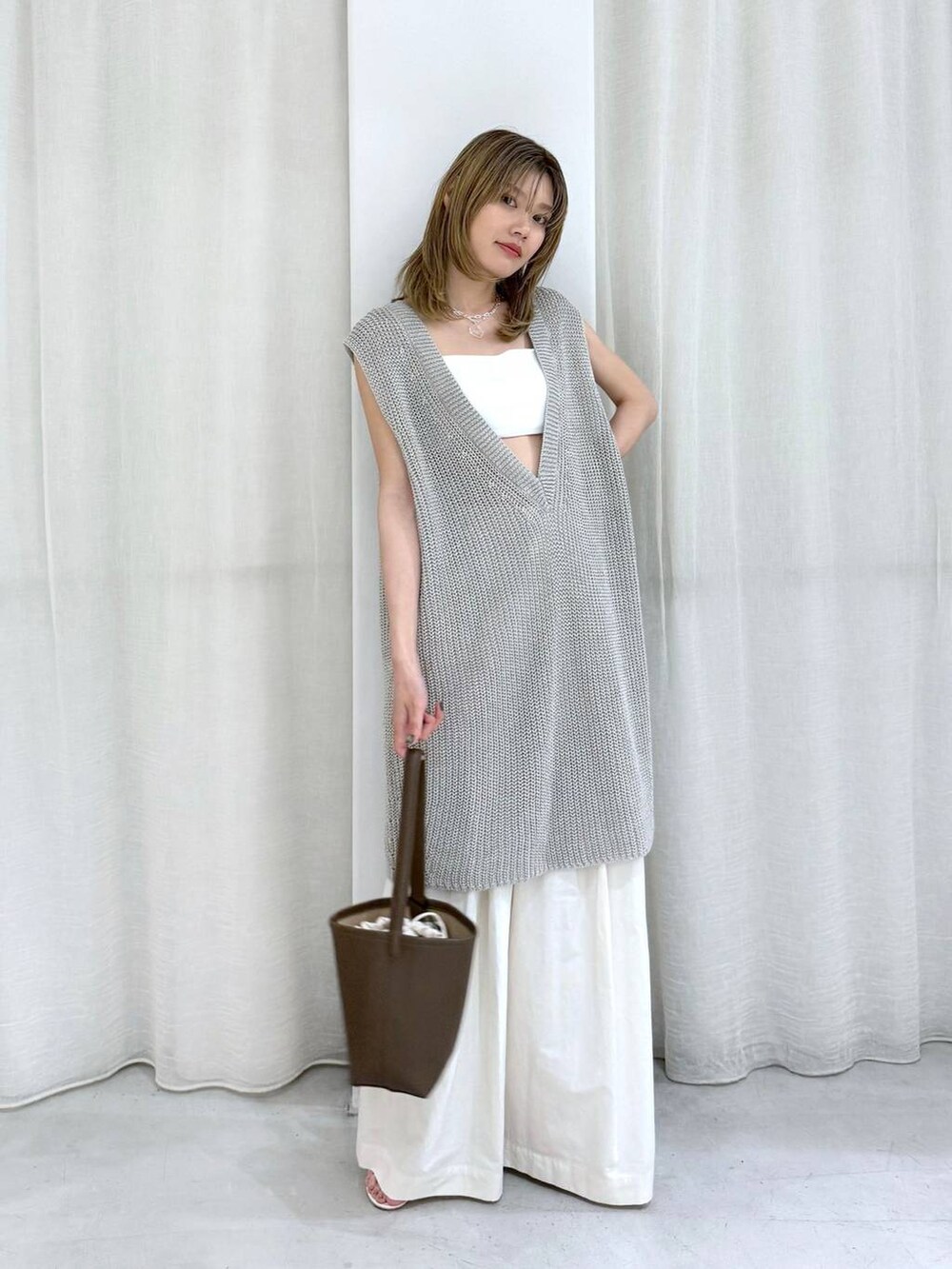 ベージュ系のニット/セーター、ホワイト系のその他パンツ、ホワイト系のインナーウェア/肌着を着用したレディースの夏コーディネートの2枚目の写真