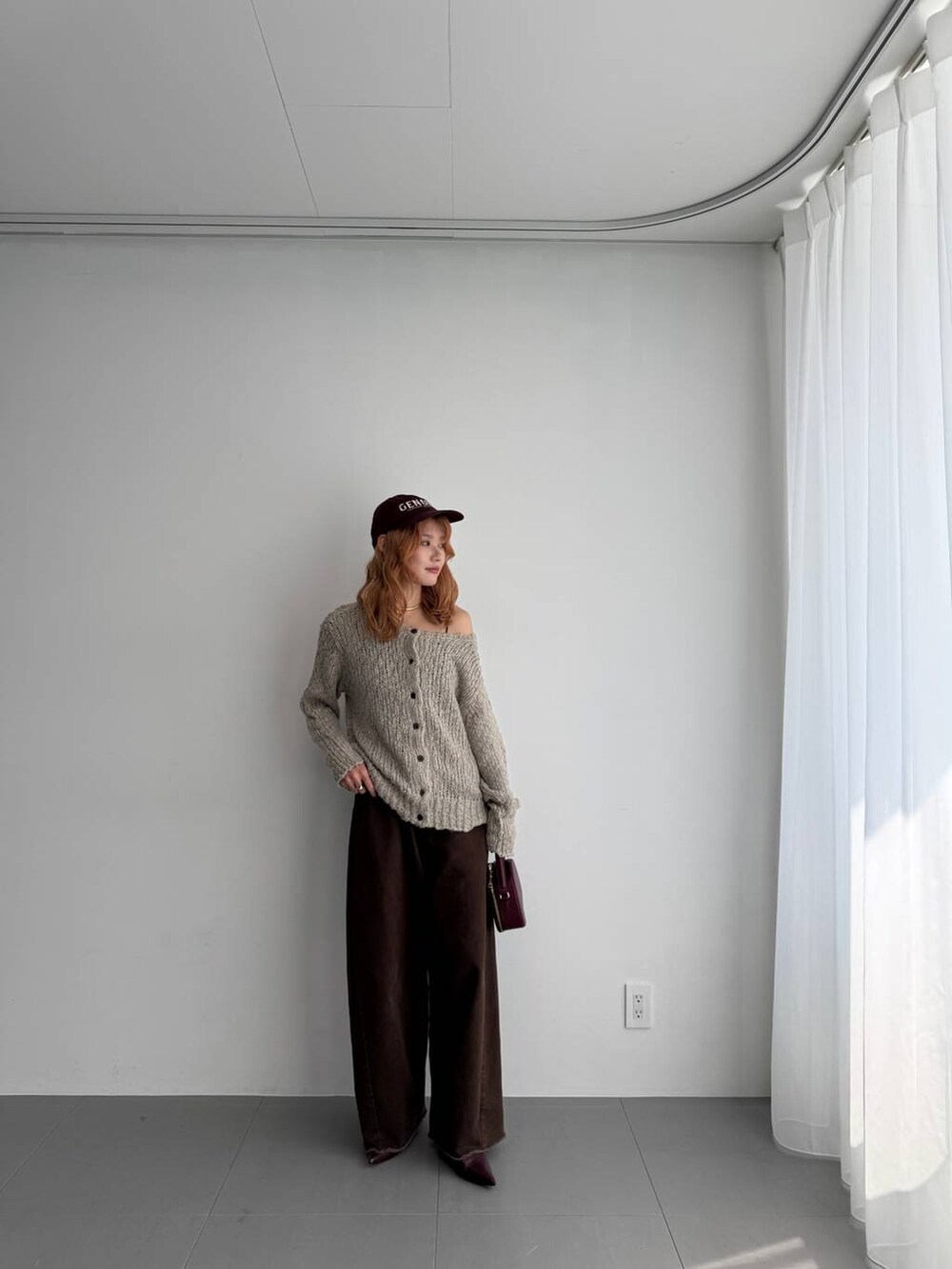 グリーン系のニット/セーター、レッド系のハンドバッグ、レッド系のブーツを着用したレディースの秋コーディネートの2枚目の写真