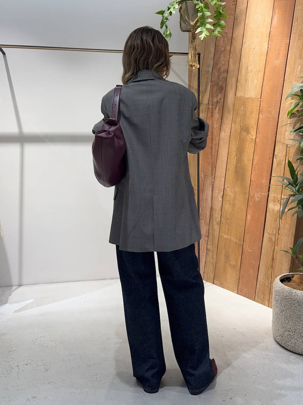 レッド系のパンプス、ブラウン系のテーラードジャケット、ブルー系のデニムパンツを着用したレディースの秋コーディネートの7枚目の写真