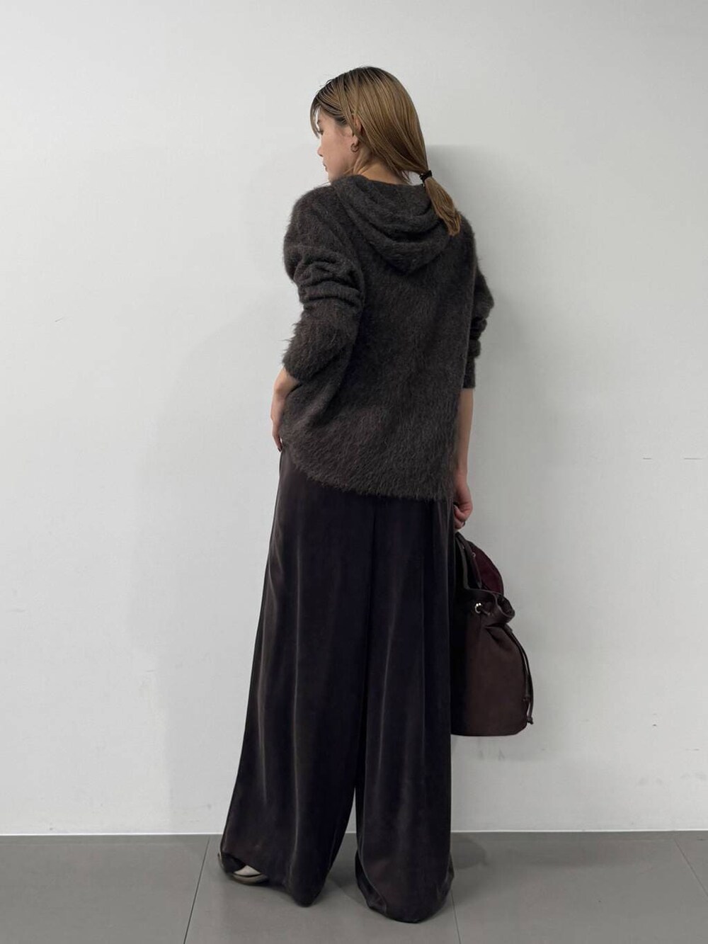 ブラウン系のその他パンツ、ブラウン系のニット/セーター、ブラウン系のトートバッグを着用したレディースの冬コーディネートの5枚目の写真