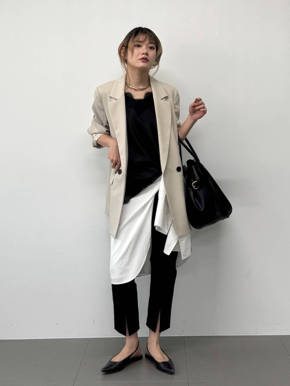 ブラック系のボストンバッグ、ベージュ系のテーラードジャケット、ブラック系のその他パンツを着用したレディースの春コーディネートの5枚目の写真
