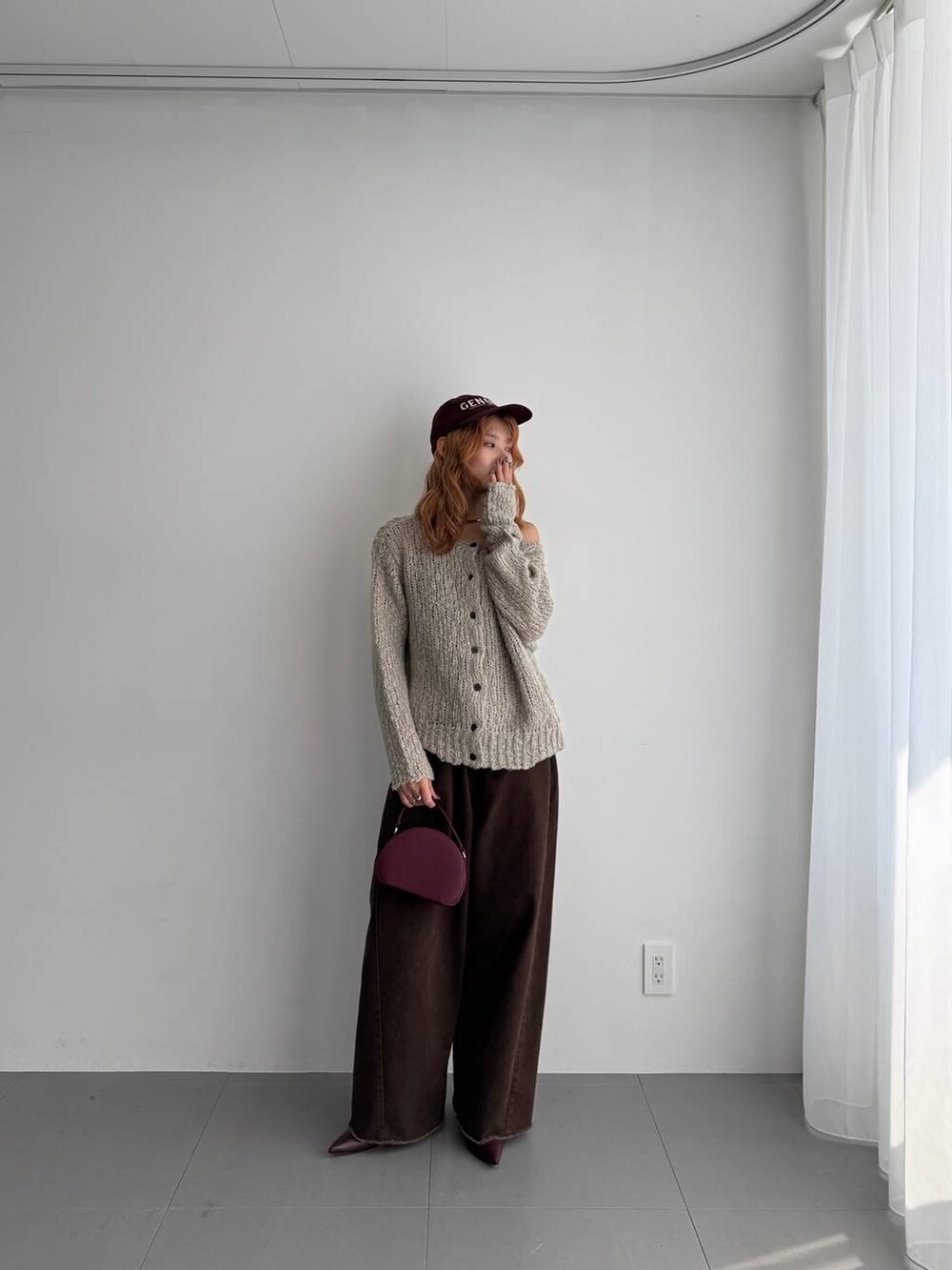 グリーン系のニット/セーター、レッド系のハンドバッグ、レッド系のブーツを着用したレディースの秋コーディネートの7枚目の写真