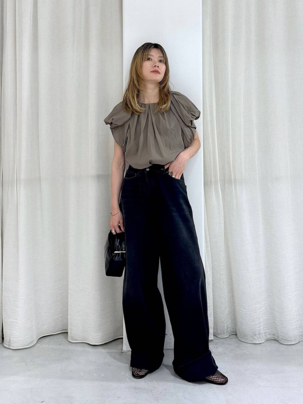 ブラック系のデニムパンツ、ベージュ系のシャツ/ブラウスを着用したレディースの夏コーディネートの3枚目の写真