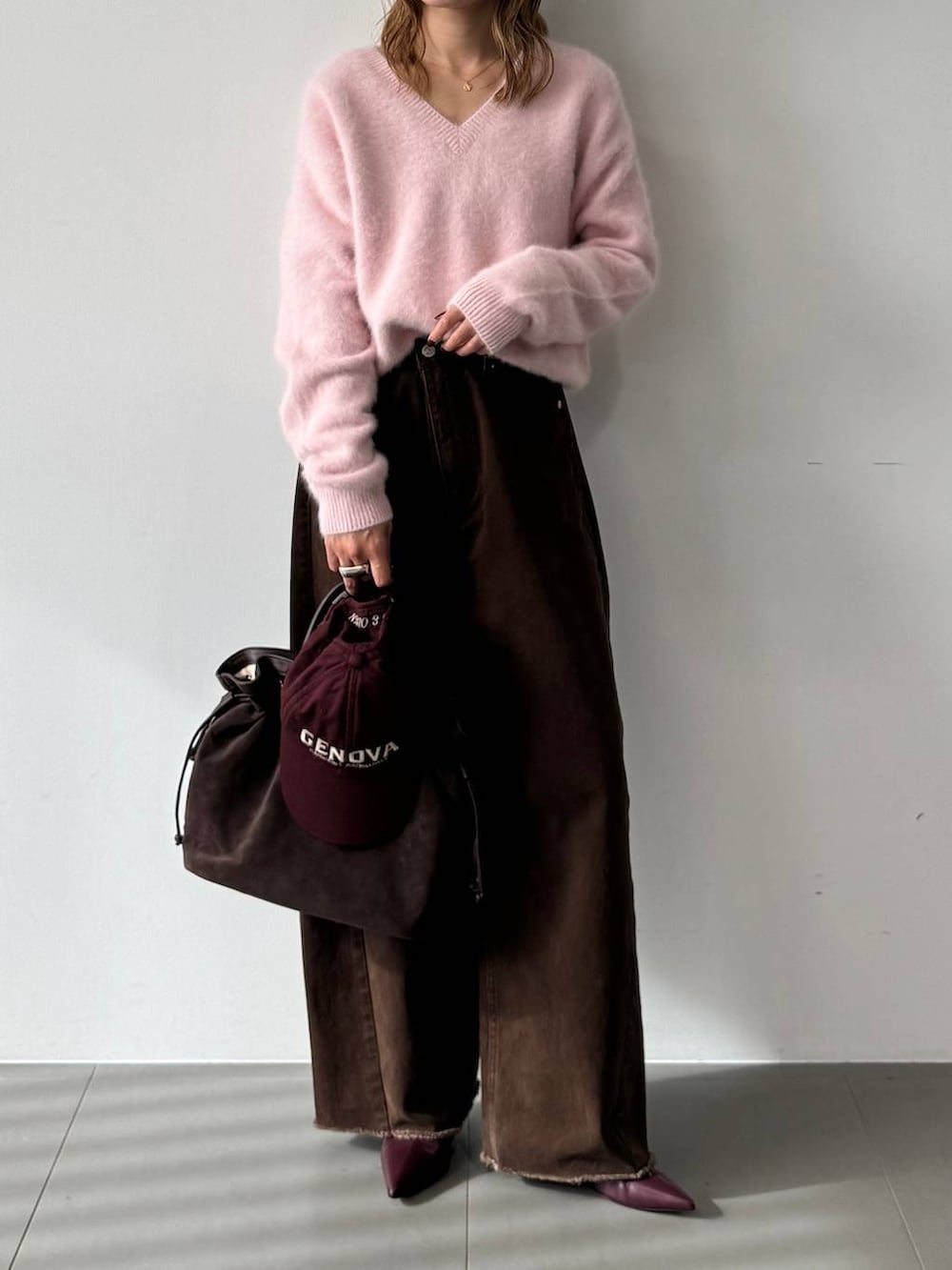 ピンク系のニット/セーター、レッド系のブーツ、ブラウン系のトートバッグを着用したレディースの秋コーディネートの7枚目の写真