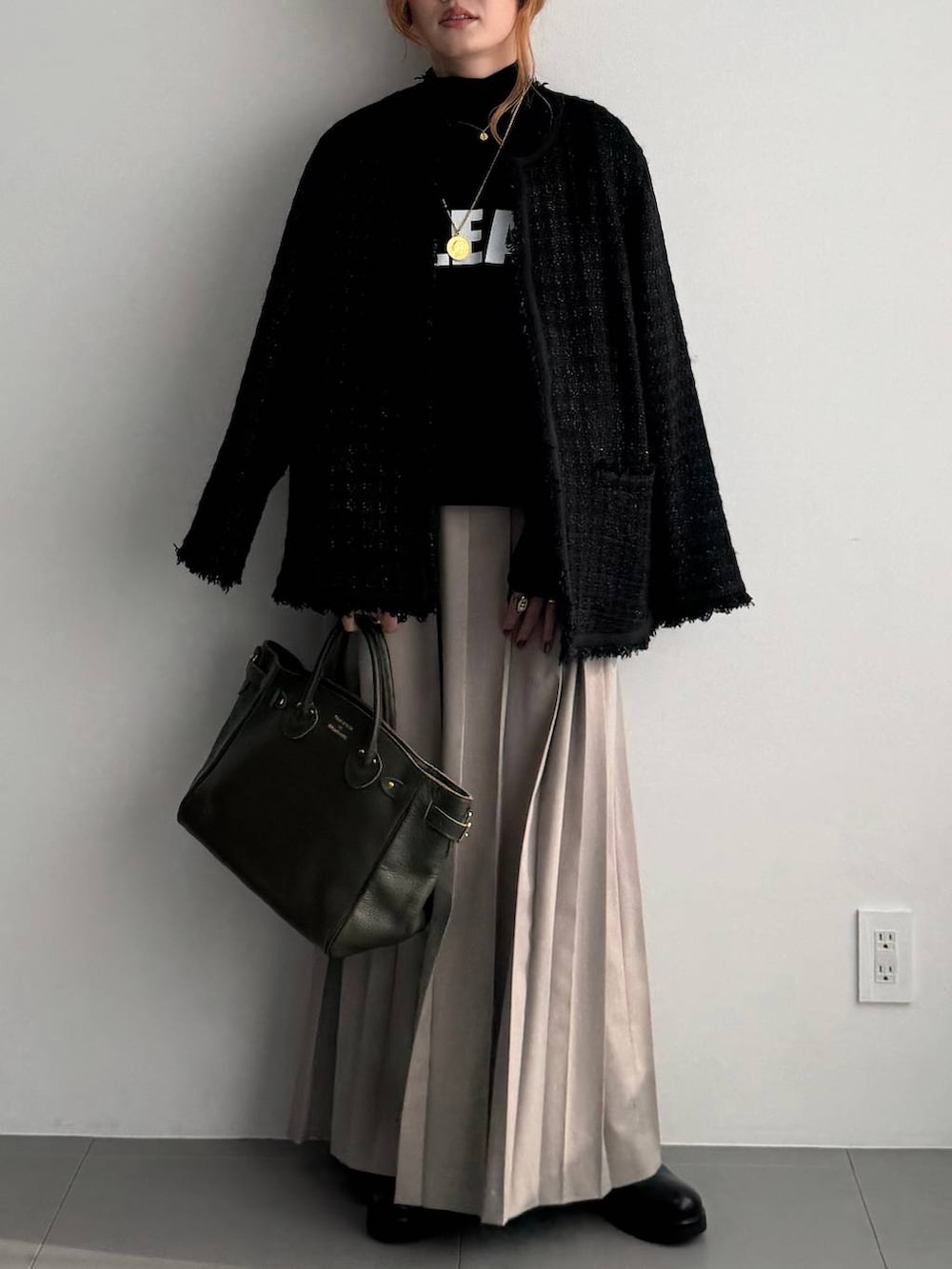 ベージュ系のスカート、ブラック系のその他アウター、ブラック系のTシャツ/カットソーを着用したレディースの秋コーディネートの3枚目の写真