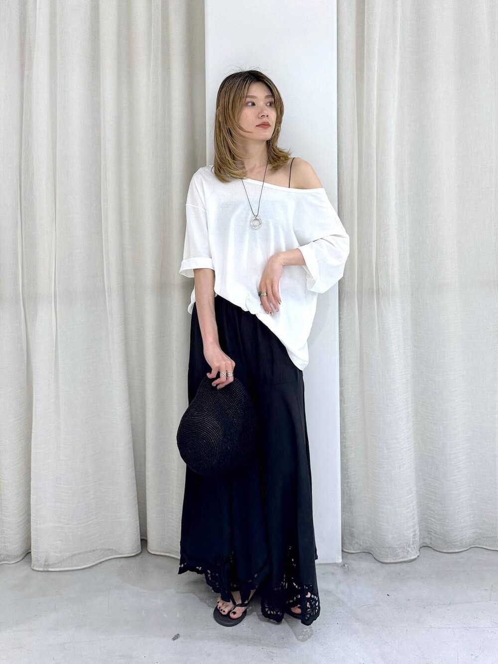 ブラック系のスカート、ブラック系のサンダル、ホワイト系のTシャツ/カットソーを着用したレディースの夏コーディネートの4枚目の写真