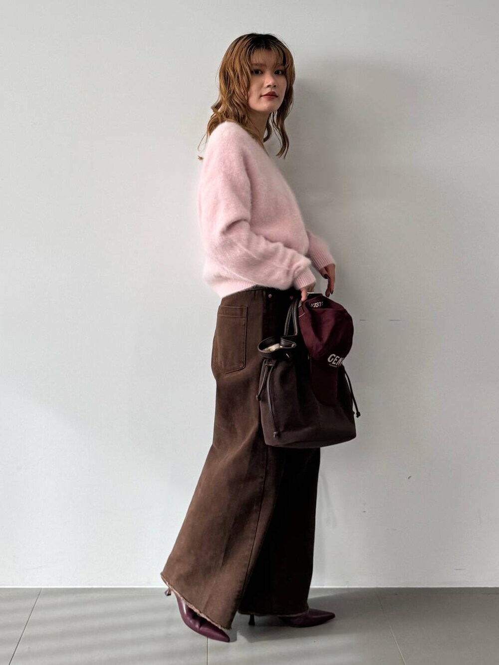 ピンク系のニット/セーター、レッド系のブーツ、ブラウン系のトートバッグを着用したレディースの秋コーディネートの4枚目の写真